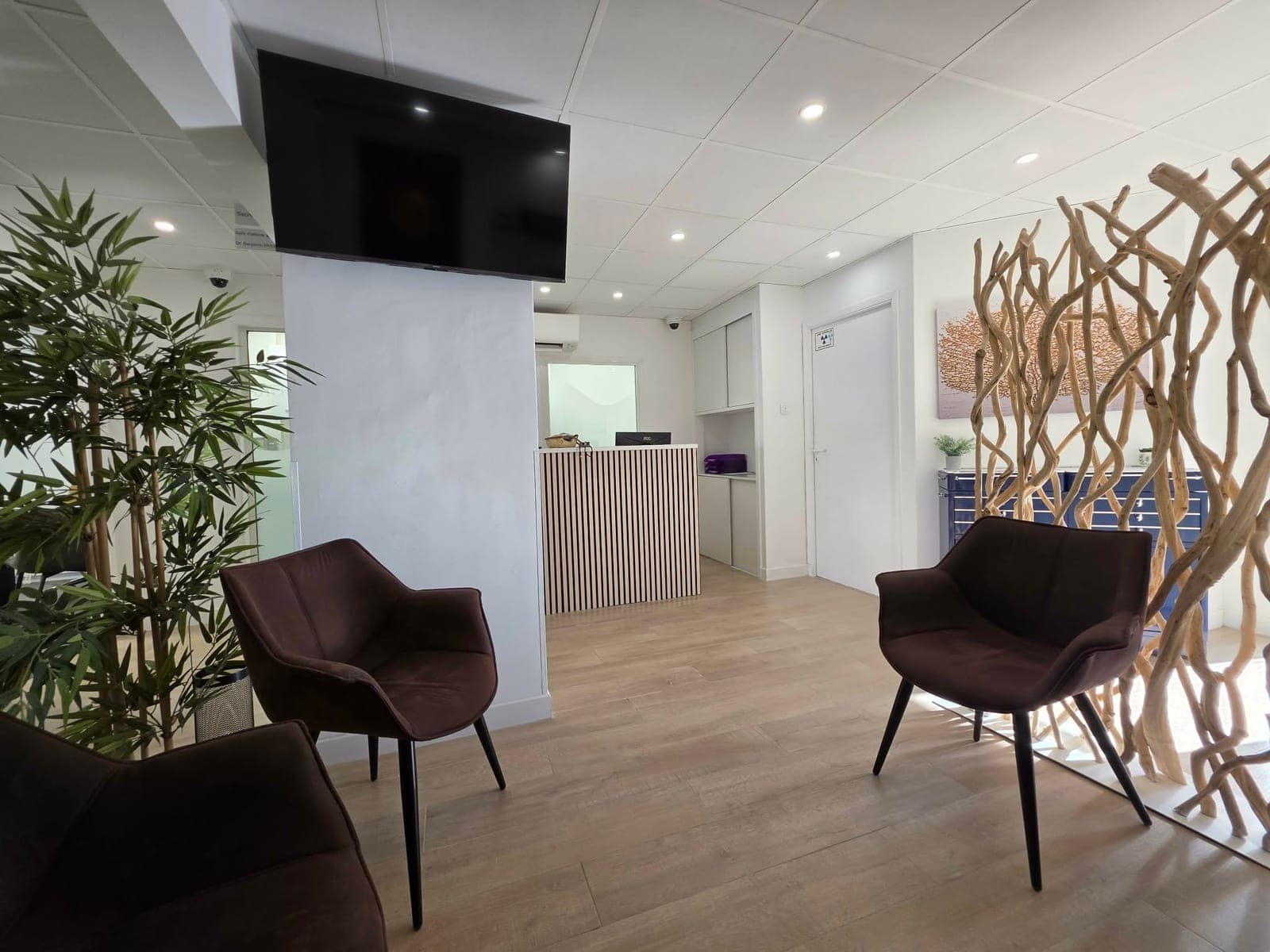 Salle d'attente du cabinet avec fauteuils et décoration en bois