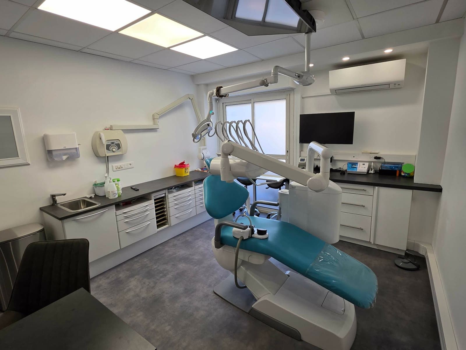 Salle de soins lumineuse équipée d'un fauteuil dentaire