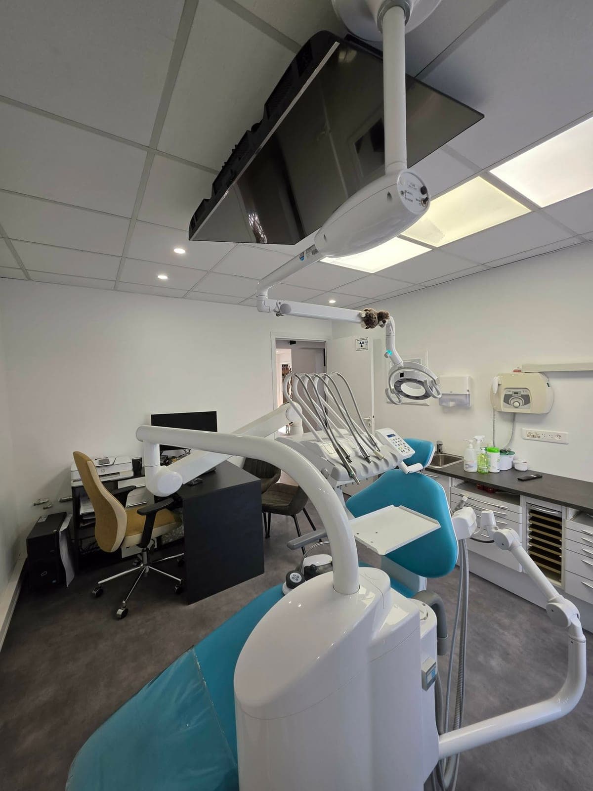 Salle de soins du cabinet équipée d'un fauteuil dentaire moderne